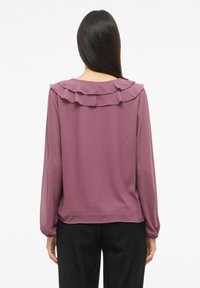 Langermet bluse i malva med rysjedetalj på kragen, laget av lett stoff, med rynkede mansjetter og avslappet passform.