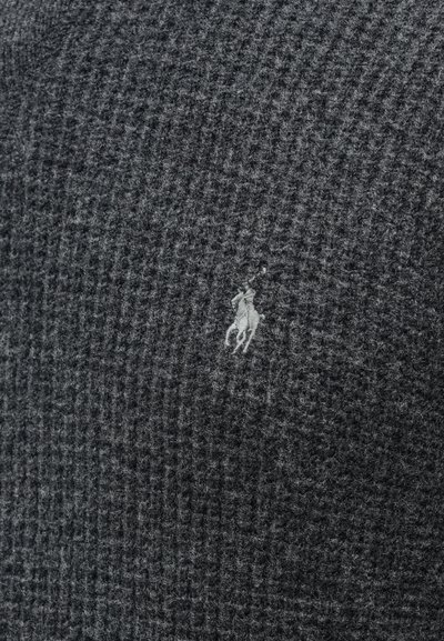 Sivi pleteni pulover z teksturiranim vzorcem; na njem je majhen, svetel vezen logotip konja in jahača.