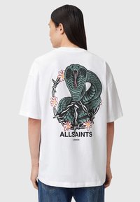 Tricou alb din bumbac, cu un grafic de șarpe verde înfășurat în flori pe spate, cu logo-ul "ALLSAINTS LONDON" deasupra. Croială lejeră.