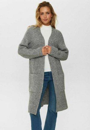Grijze gebreide cardigan met lange mouwen, open voorkant en twee voorzakken. Gelaagd patroon met een geribbelde structuur, gecombineerd met een witte top en blauwe jeans.
