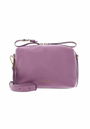 Sac bandoulière en cuir violet avec ferrures dorées, sangle ajustable et logo "Coccinelle" sur le devant.