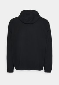 Sweat à capuche noir en coton doux. Il possède des manches longues, une poche kangourou et des poignets et un ourlet côtelés. Design plain au dos.
