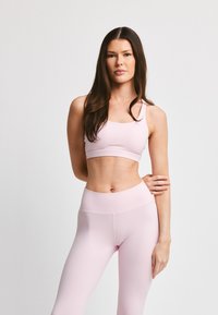 Lys rosa sport-bh og tights sett, med et glatt, elastisk stoff og en tettsittende design samt bred midjebånd for komfort.