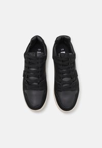 Black sneakers with a combination of textured leather and suede materials. They feature flat laces, padded collar, and a rubber sole. Size 41.