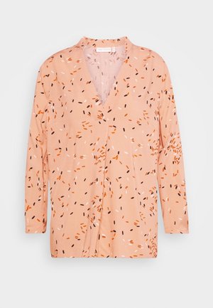 Haut pêche clair à manches longues, décolleté en V et motifs abstraits éparpillés en orange, noir et blanc. Tissu doux avec une coupe décontractée.