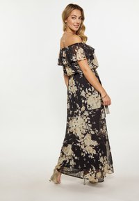 Schwarzes Maxikleid mit schulterfreiem Rüschenausschnitt, das mit cremefarbenen und gelben Blumenmustern verziert ist, aus leichtem Stoff und mit einem fließenden Schnitt.