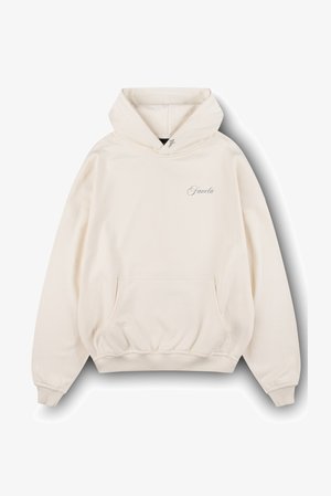 Sudadera con capucha color crema, hecha de tela suave, con un bolsillo frontal tipo canguro, puños acanalados y un pequeño logo bordado en el pecho.