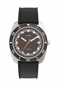 Montre quartz Timex avec un bracelet en caoutchouc noir, un boîtier en argent et un cadran gris foncé. Présente des accents rouges, des marqueurs luminescents et un affichage de la date.