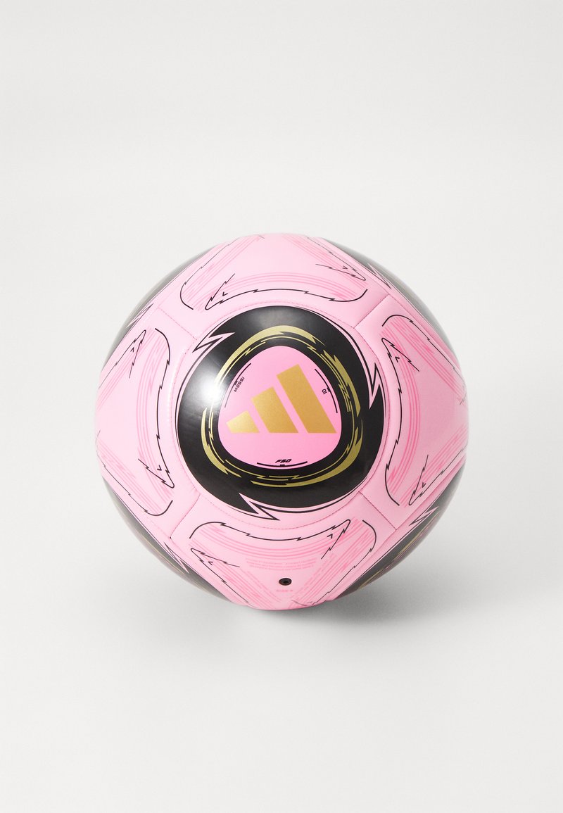 Ružová futbalová lopta s čiernymi a zlatými detailmi, s obvodovými vzormi a textúrovaným povrchom, na ktorom sa nachádza výrazný dizajn trojprúžku.