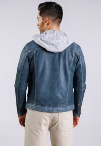Herren Lederjacke in Blau mit grauem Kapuzen, ausgestattet mit silbernen Reißverschlüssen, glatter Textur und taillierter Passform. Die Rückansicht zeigt Nahtdetails.