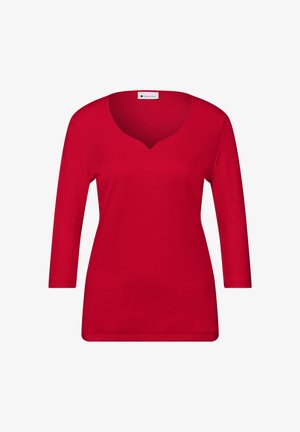 Chemise longue à manches longues pour femmes, rouge, avec un décolleté en V et un ourlet droit, présentée sur un fond blanc.