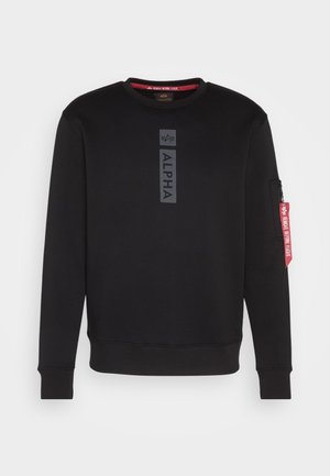 Zwarte sweatshirt met ronde hals, met een opvallend "ALPHA" logo in het midden en een zip pocket op de mouw met een rode label. Zachte stof.