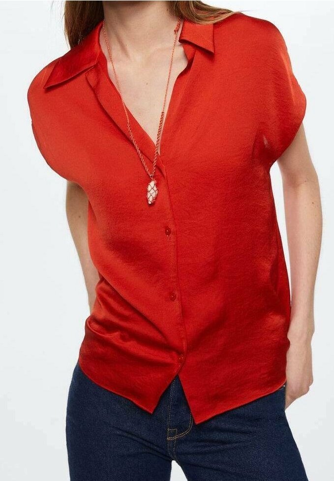Blouse rouge à manches courtes avec un devant à boutons, un col classique et une texture lisse, associée à un collier superposé.