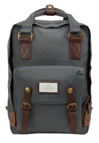 Sac à dos en tissu gris avec poche avant, bretelles en cuir marron, boucles en laiton et poignée supérieure avec fermeture à bouton, étiqueté "Doughnut."