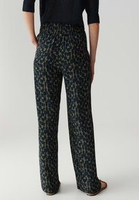 Pantalons amples en marine foncé avec un motif géométrique en olive. Comprend une taille élastique et un tissu léger.