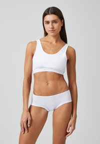 Witte katoenen bralette en boyshort set. De bralette heeft een ronde halslijn en brede straps. De shorts hebben een elastische tailleband en een gladde textuur.