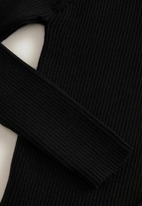Schwarzes geripptes Strickoberteil mit langen Ärmeln und strukturierter Passform. Die Textur ist glatt und zeigt vertikale Linien im gesamten Stoff.
