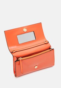 Cartera de charol naranja con cierre de presión y espejo. Cuenta con un bolsillo con cremallera y ranuras internas para tarjetas, con detalles en hardware dorado.