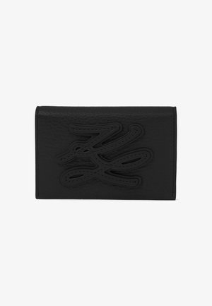 Portefeuille en cuir noir avec un design abstrait embossé centré sur le rabat avant, présenté sur un fond blanc.
