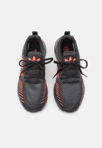 Svart atletiska skor med orange accenter, med en stickad ovandel, runda snören, texturerad mellanmaterial och mönstrad sula.