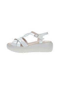 Sandalias de charol blanco con diseño de tiras cruzadas, hebilla ajustable y una suela de plataforma gruesa blanca para mayor altura y comodidad.