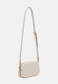 Světlobéžová crossbody taška s texturovaným koženým povrchem, zipovým uzávěrem, zlatými detaily a nastavitelného popruhem s hnědými akcenty.