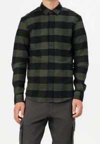 Camicia a quadri verde e nera, con maniche lunghe, in tessuto di cotone, dotata di colletto standard e bottoni neri.