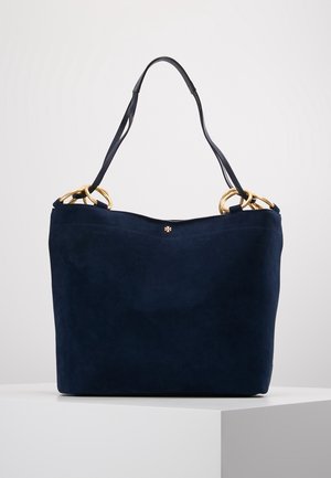 Marineblaue Wildleder-Handtasche mit einem schwarzen Lederschulterriemen und goldfarbenen Metallringen an den oberen Kanten.