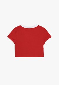 Rød cropped t-shirt med hvid krave, korte ærmer og en blød tekstur. Enkel design uden udsmykninger eller mønstre.