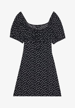 Svart kort kjole med hvite uregelmessige prikkede mønster, puffede ermer, firkantet halslinje og knyting foran.