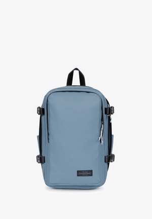 Sac à dos rectangulaire bleu avec poignée noire, boucles latérales noires et poche zippée à l’avant sur fond blanc.