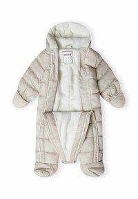 Combinaison de ski beige matelassée avec une douce doublure blanche, capuche, poignets élastiques et fermeture éclair à l'avant. Présente de subtils motifs clairs sur l'extérieur.
