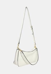 Borsa a tracolla in pelle bianca con bordi neri, forma curvata, tracolla regolabile e dettagli in metallo dorato. Texture liscia e design minimalista.