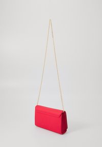 Rød faux lær clutch-veske med gullkjedehank, rektangulær form, glatt tekstur og klaffelukking på toppen.