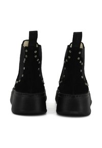 Stivali alla caviglia in suede nero con design alto, caratterizzati da dettagli metallici lungo i lati, suole in gomma nera spessa e linguette per un facile indossamento.