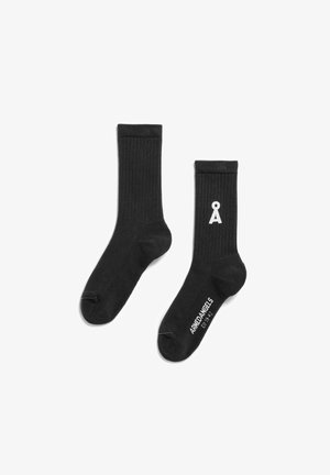 Schwarze, gerippte Socken mit einem weißen Logo auf einer Seite und Schriftzug an der Sohle. Hergestellt aus einem weichen, dehnbaren Material.