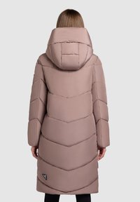 Long, padded coat in light pink with a chevron design, featuring a large hood and subtle logo detail on the lower left side.