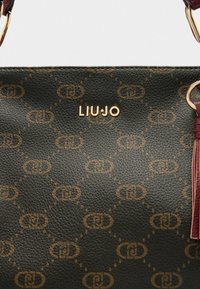 Crna teksturirana kožna torba s smešnim uzorkom smešnog logotipa, koja sadrži zlatni emblem "LIUJO" i maroon akcentima sa čuperkom.