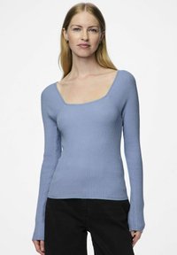 Šviesiai mėlyna ribota ilgomis rankovėmis palaidinė su kvadrato formos iškirpte ir prigludusia forma, su tekstūruotu audiniu ir šiek tiek išsiplėtusiomis rankovėmis.