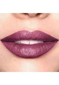Matowa szminka w głębokim odcieniu mauve z połyskującym wykończeniem. Usta są pełne i równomiernie pokryte, z widocznymi drobnymi detalami tekstury.