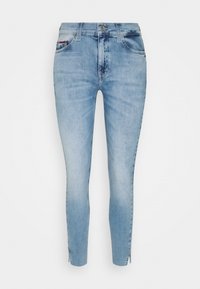 Jeans ajustados de color azul claro con un acabado desgastado, que cuentan con cinco bolsillos, cierre de botón y cremallera, y cremalleras en los tobillos para un ajuste ajustable.