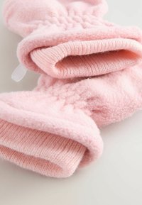Pink fleece mittens with ribbed textured cuff, featuring a soft fabric and curved shape, designed for warmth and comfort.