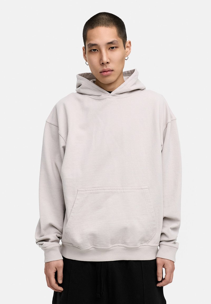 Helles graues Hoodie aus weichem Material. Verfügt über eine vordere Kängurutasche, weite Ärmel und eine Kapuze mit Kordelzug. Einfaches Design, lockere Passform.