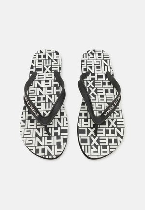 Infradito in bianco e nero con un motivo testuale ripetuto e cinturini in gomma nera con il marchio "Armani Exchange". Design con suola piatta.