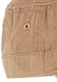 Brun bomulds-kappe med en tekstureret overflade, der har sømdetaljer og et ventilationshuller. Rund form med en blød, fleksibel skygge.
