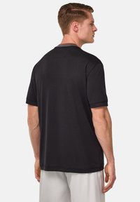 Black short-sleeve t-shirt made of smooth fabric, featuring a crew neck, stitched hems, and a subtle back detail.