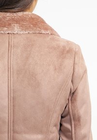 Lyserød faux suede jakke med en blød krave, detaljeret syning og en blød tekstur, der har en skræddersyet pasform og rene linjer ved ryggen.