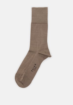 Chaussette en coton marron avec un poignet côtelé, texture lisse et un logo imprimé sur le côté. Présente un design classique et minimaliste.