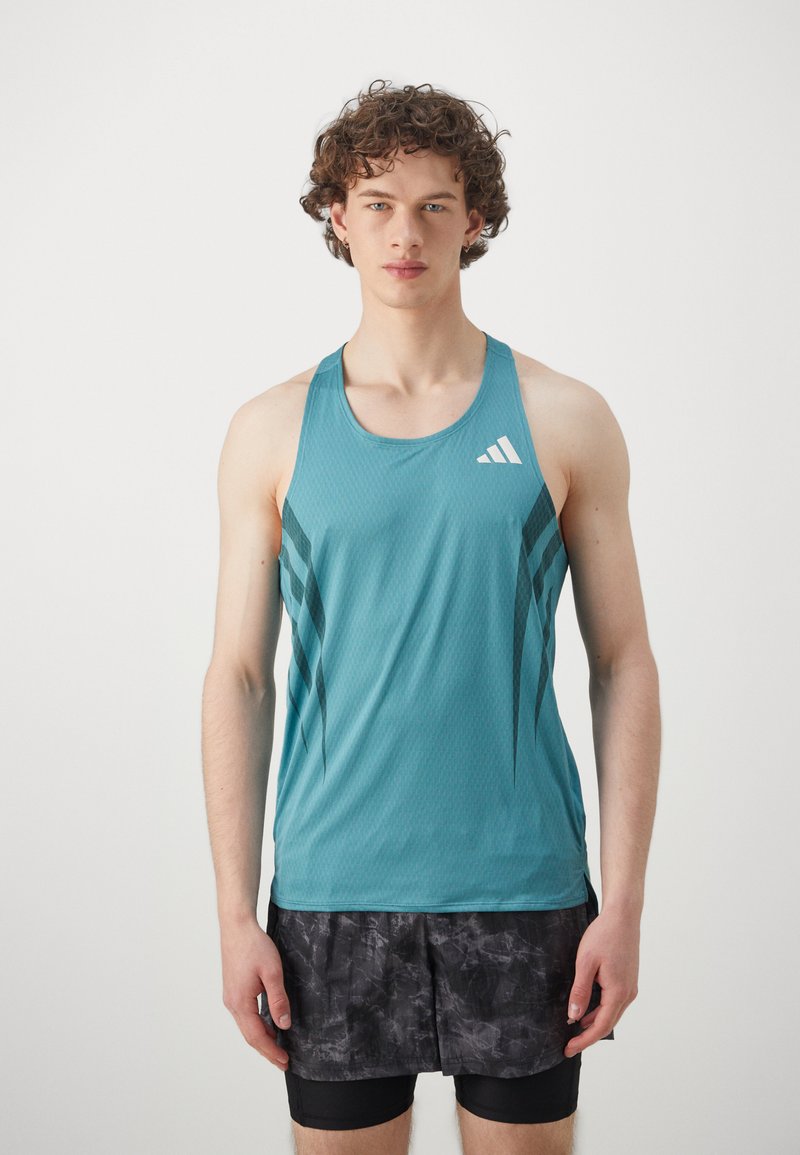 Türkiisi sportlik tank top, millel on tekstureeritud muster, tumedad diagonaalsed triibud ja valge logo vasakul rinnal, koos mustade lühikesed pükstega.