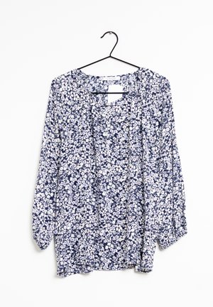 Blusa floreale a maniche lunghe con uno sfondo blu navy e motivi di fiori bianchi e rossi, tessuto leggero e vestibilità ampia.